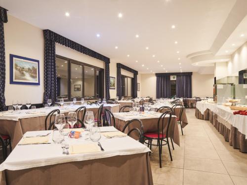 布伦托尼科波尔萨酒店的用餐室配有桌椅和白色的桌布