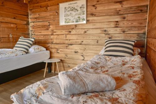 米湖Hlíd Huts的卧室设有木墙、一张床和枕头。