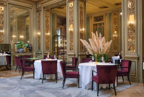 巴勒莫艾特德斯帕尔梅斯大酒店的一间设有两张桌子和红色椅子的用餐室