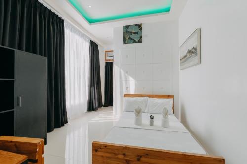奥斯洛布The Marc Vannelli Oslob的卧室配有白色床和绿色天花板
