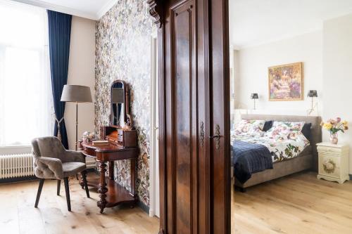 贝茨泰兹瓦赫De Jonge Barones的一间卧室配有一张床和一张桌子及椅子