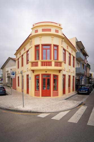 波瓦-迪瓦尔津A'MAR by Alojamento Ideal的街道拐角处的黄色和红色建筑