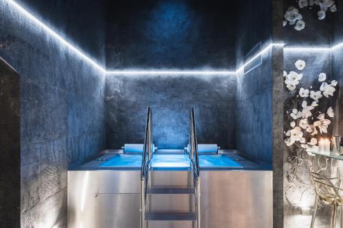 多布日什Royal Apartmány的一间带蓝色浴缸及梯子的浴室