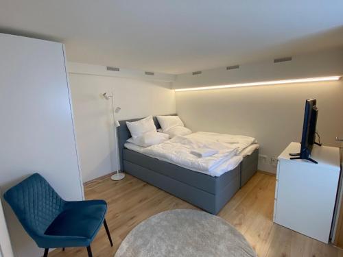 普福尔茨海姆Mini Apartment mit Bad und Küche的一间小卧室,配有一张床和一张蓝色椅子