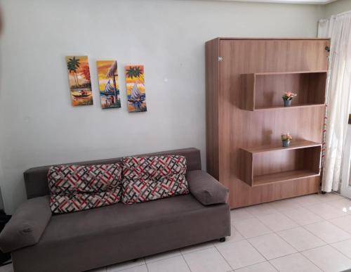 特拉曼达伊Aluguel Temporada Tramandai Proximo à Praia的客厅设有棕色的沙发和架子