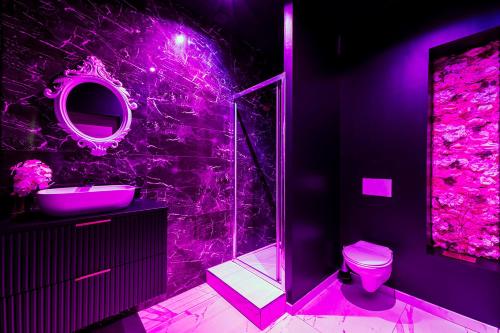 Le BreuilSweet SECRET'S JACUZZI的紫色浴室设有卫生间和水槽