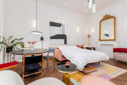 克拉科夫Estery Colourful Luxury Apartment的卧室配有一张床和一张桌子及椅子