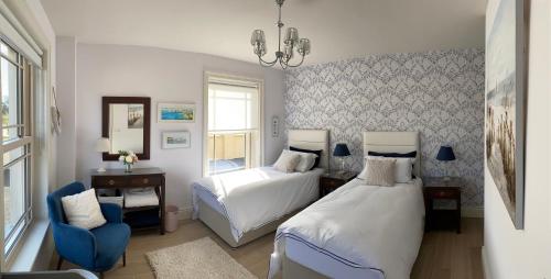 恩尼斯基林Radharc Na Cuilcagh的一间卧室配有两张床和一张蓝色椅子