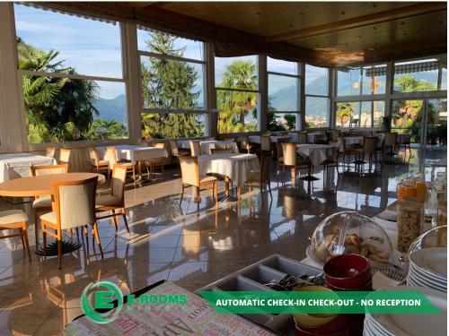 洛迦诺E-Rooms Minusio的餐厅设有桌椅和窗户。