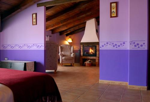 特拉马卡斯蒂利亚圣安娜旅馆的一间卧室设有紫色墙壁和壁炉