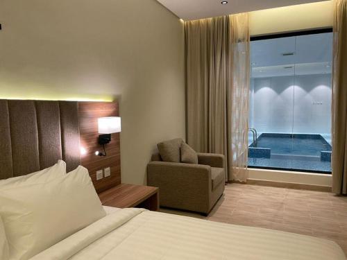 Qarārشاليهات دبليو سويتس الدرب的酒店的客房 - 带一张床、椅子和窗户