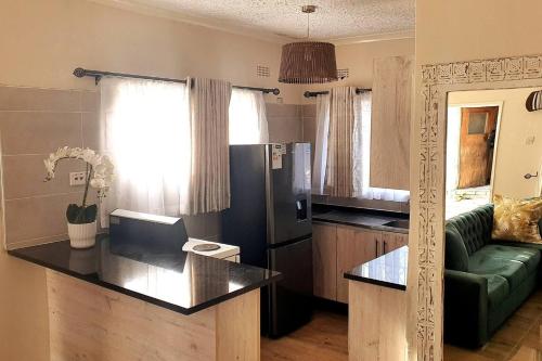 哈拉雷Gorgeous 1-Bed apartment in Harare的一间厨房和客厅,客厅内配有绿色沙发