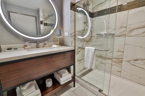 伯利恒Wind Creek Bethlehem Casino & Resort的带淋浴、盥洗盆和镜子的浴室