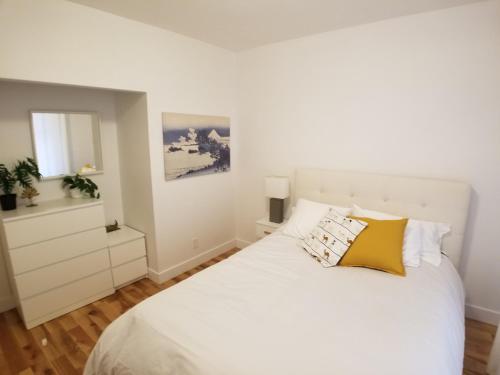 蒙特利尔3 bedroom near Olympic Stadium的卧室配有白色的床和镜子