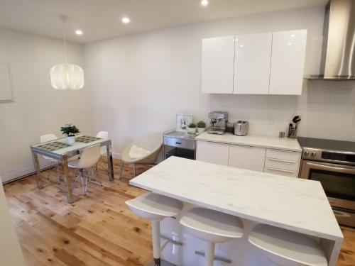 蒙特利尔3 bedroom near Olympic Stadium的厨房配有白色橱柜和桌椅