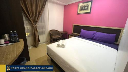 安邦Hotel Grand Palace Ampang的一间卧室配有一张床和粉红色的墙壁
