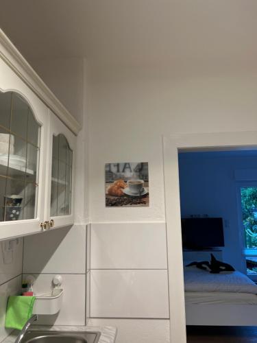 克雷费尔德Appartement am Teich的厨房配有白色橱柜和水槽