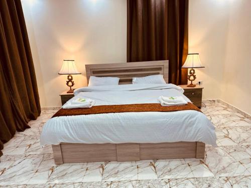 杰拉什Dream house hotel jerash的一间卧室配有一张大床和两盏灯
