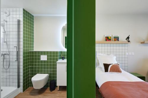 拉贝格Hife Toulouse Labège的绿色和白色的浴室设有一张床和淋浴