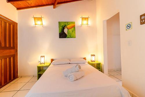 阿拉亚尔达茹达Na Casa 11 - Pousada e Hostel的一间卧室,配有一张带两盏灯的床和一幅鸟图