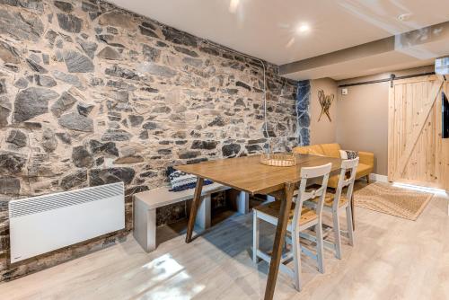 魁北克市Beautiful Vieux 2 Bedroom Apt的一间拥有石墙的用餐室