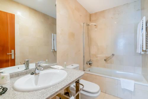 蓬费拉达庞费拉达广场酒店的浴室配有盥洗盆、卫生间和浴缸。