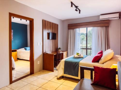 卡内拉Luzzy Hotel的酒店客房,设有两张床和镜子
