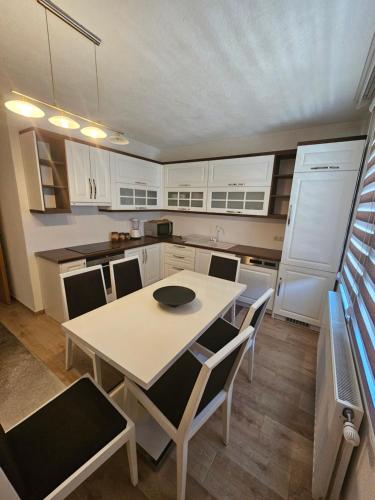 普里兹伦Dardania-Home的厨房配有桌椅和白色橱柜。