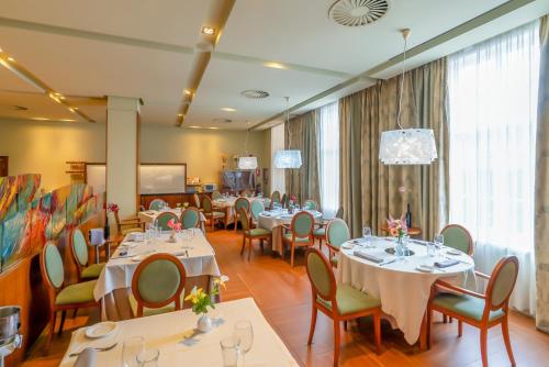 蓬费拉达庞费拉达广场酒店的餐厅设有桌椅和大窗户。