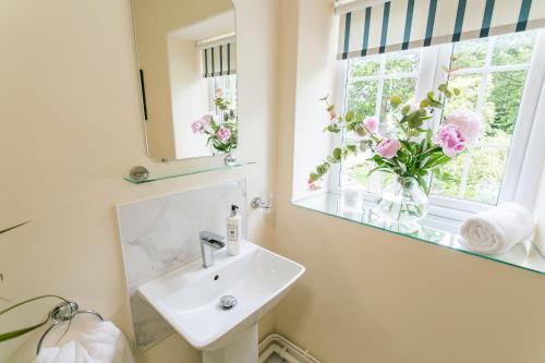 兰韦尔弗亨Cae Mab Dafydd的一间带水槽的浴室和鲜花窗户