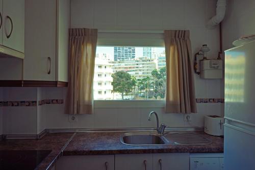 贝尼多姆轻帆船公寓的厨房设有水槽和窗户。