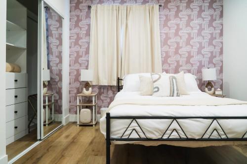 英格尔伍德The Relyn的一间卧室配有一张床和粉红色的墙壁