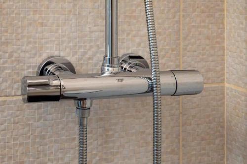 马科普隆Bovis Apartments #1的浴室内带软管的淋浴头