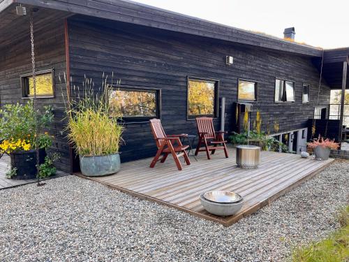 特罗姆瑟Håkøya Lodge的房屋内带两把椅子的木制甲板