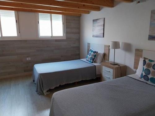 罗萨里奥港Loft moderno en Fuerteventura的一间卧室设有两张床和两个窗户。
