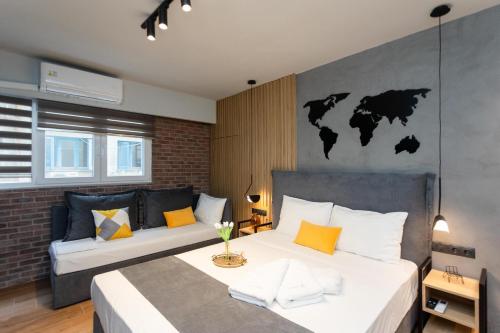 塞萨洛尼基Valaoritou 3 Luxury Rooms的一间卧室设有两张床,墙上挂有一张世界地图