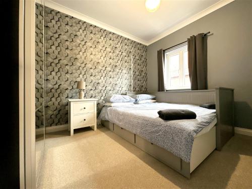 利兹Cheerful two-bedroom townhouse near Leeds and York的一间卧室设有一张床和玻璃墙