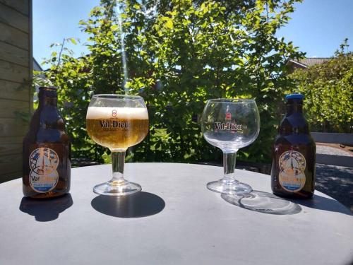 DisonCôté jardin的桌子上放两瓶和两杯啤酒