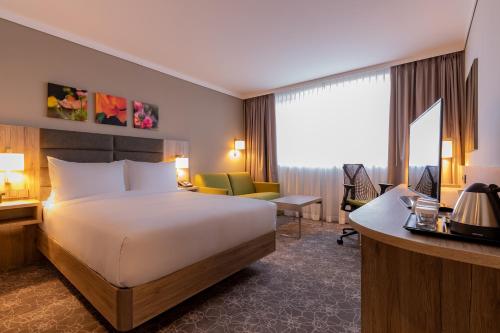 维也纳新城Hilton Garden Inn Wiener Neustadt的配有一张床和一张书桌的酒店客房