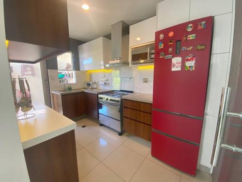 圣克鲁斯Hermosa casa en cond. privado的厨房配有带磁铁的红色冰箱