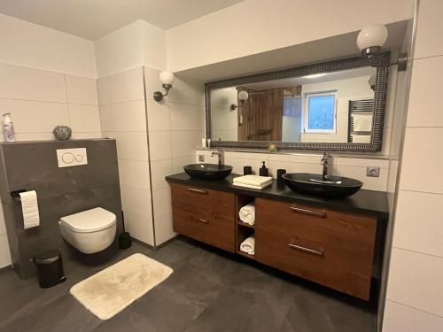 HeideblickWormis Apartment Heideblick bei Luckau的浴室设有2个水槽、卫生间和镜子。
