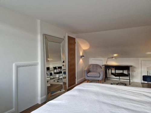 伦敦Luxury London Oasis的一间卧室配有一张床、一张书桌和一面镜子