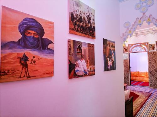 梅克内斯Riad Sibari的墙上挂有绘画的房间
