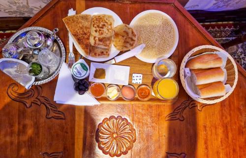 梅克内斯Riad Sibari的一张木桌,上面有面包和其他食物