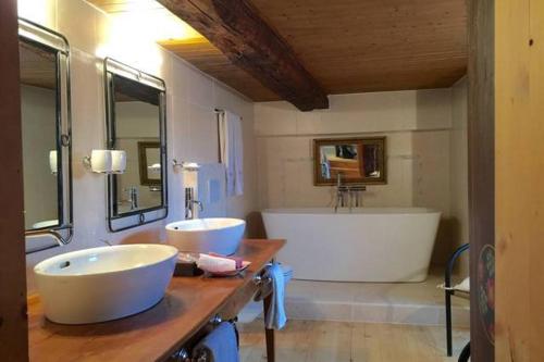 瓦尔·蒂利兹Les Quatre Saisons - balcon et jardin的浴室配有两个盥洗盆和浴缸。