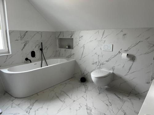 柏林Hochwertiges Haus mit Garten mit guter Anbindung的白色的浴室设有浴缸和卫生间。