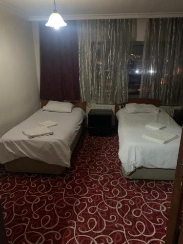 AltındağAltunlar erkek ögrenci yurdu的红地毯旅馆客房的两张床