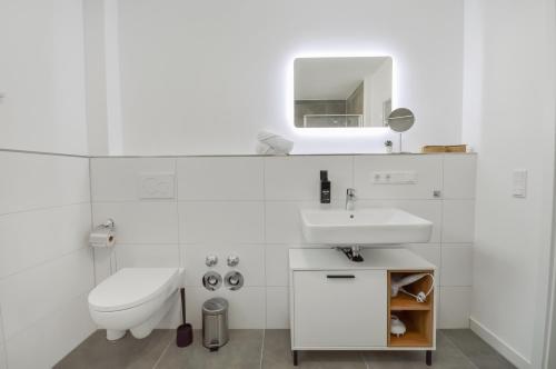 施泰因哈根Stilvolle Stadtoase - Balkon - Parkplatz的白色的浴室设有水槽和卫生间。