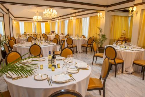 欧丘里欧Sago Palm Hotel的宴会厅配有白色的桌椅