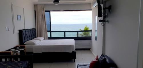 萨尔瓦多法罗尔巴拉公寓的一间卧室配有一张床,享有海景